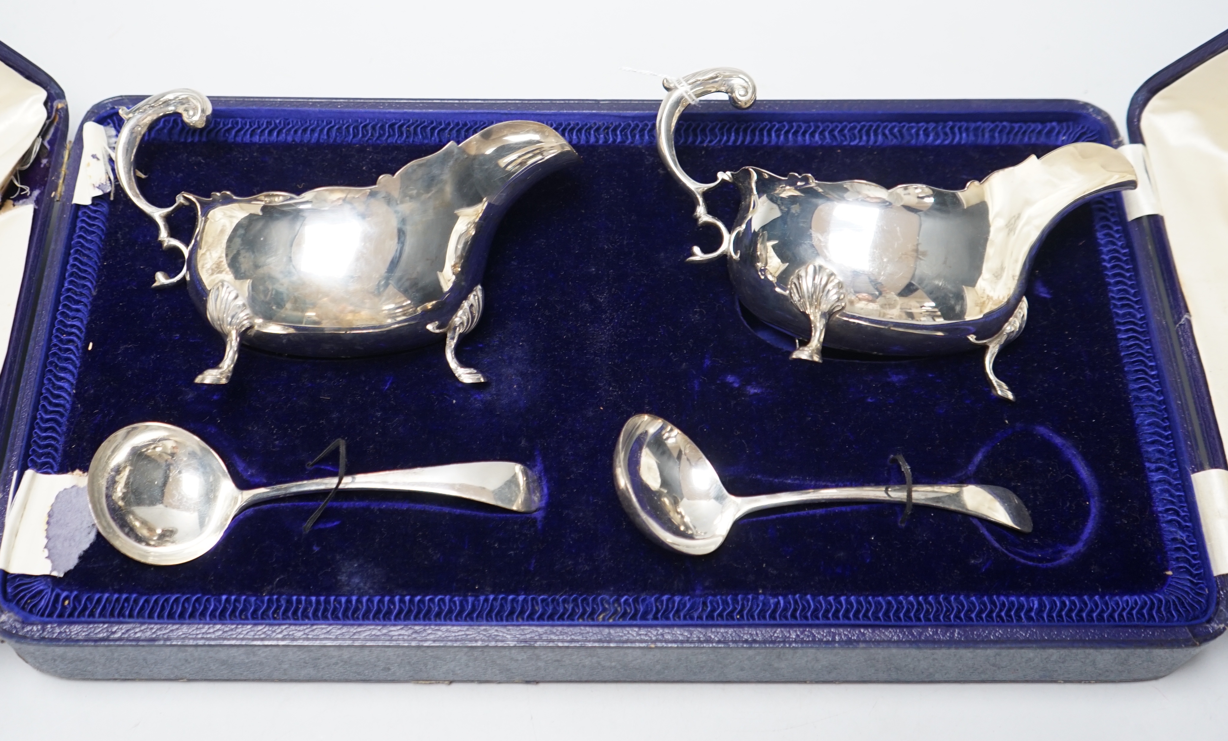 A cased pair of Edwardian silver sauceboats and pair of matching sauce ladles by Edward Barnard & Sons Ltd, London, 1909, 16.7oz.